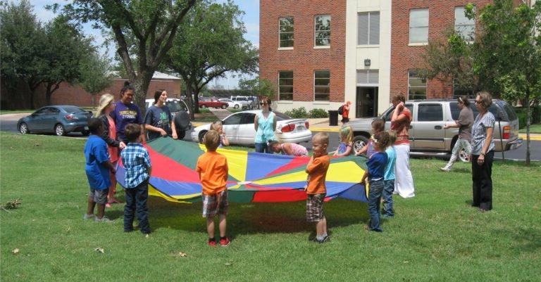 人类服务部的学生和孩子们一起玩降落伞